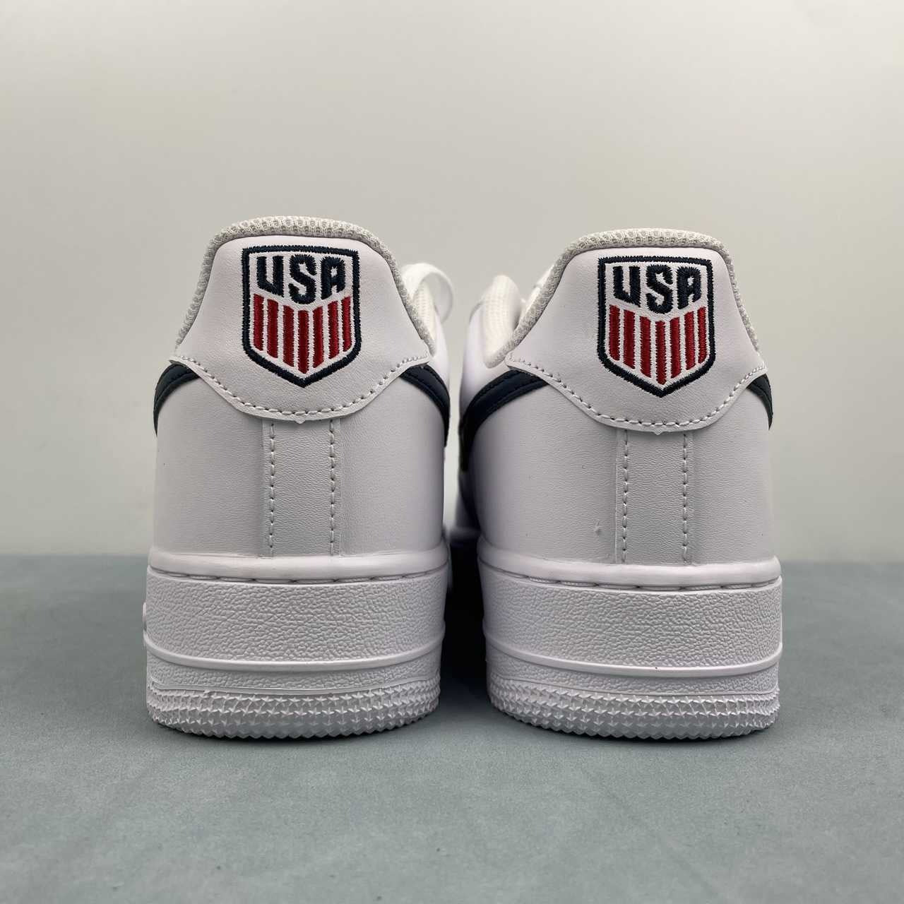 AF1-040 USA Soccer Tribute – pair on box three-quarter view showing white leather upper, navy swoosh, and silver AF1 dubrae