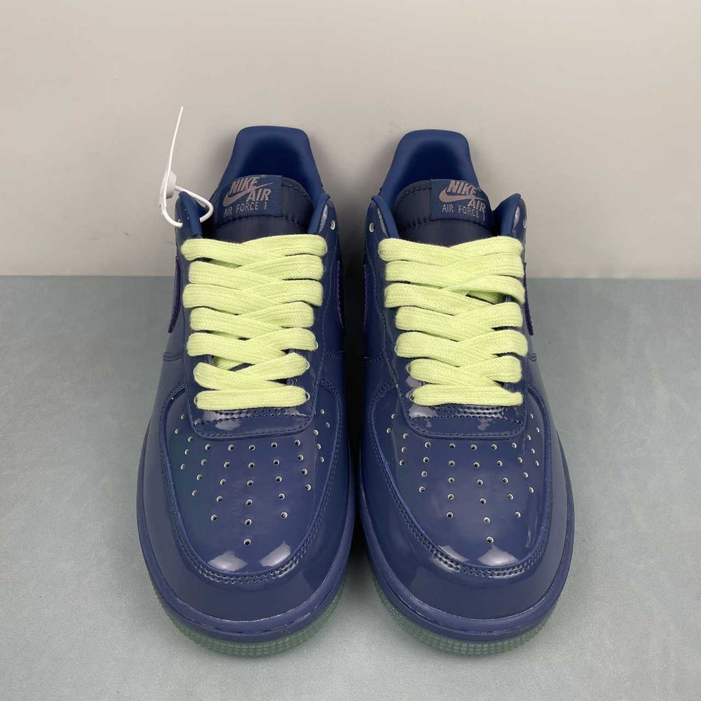 AF1-036 Tonal Navy Patent – pair on surface, three-quarter front view showing lime laces and hang tag