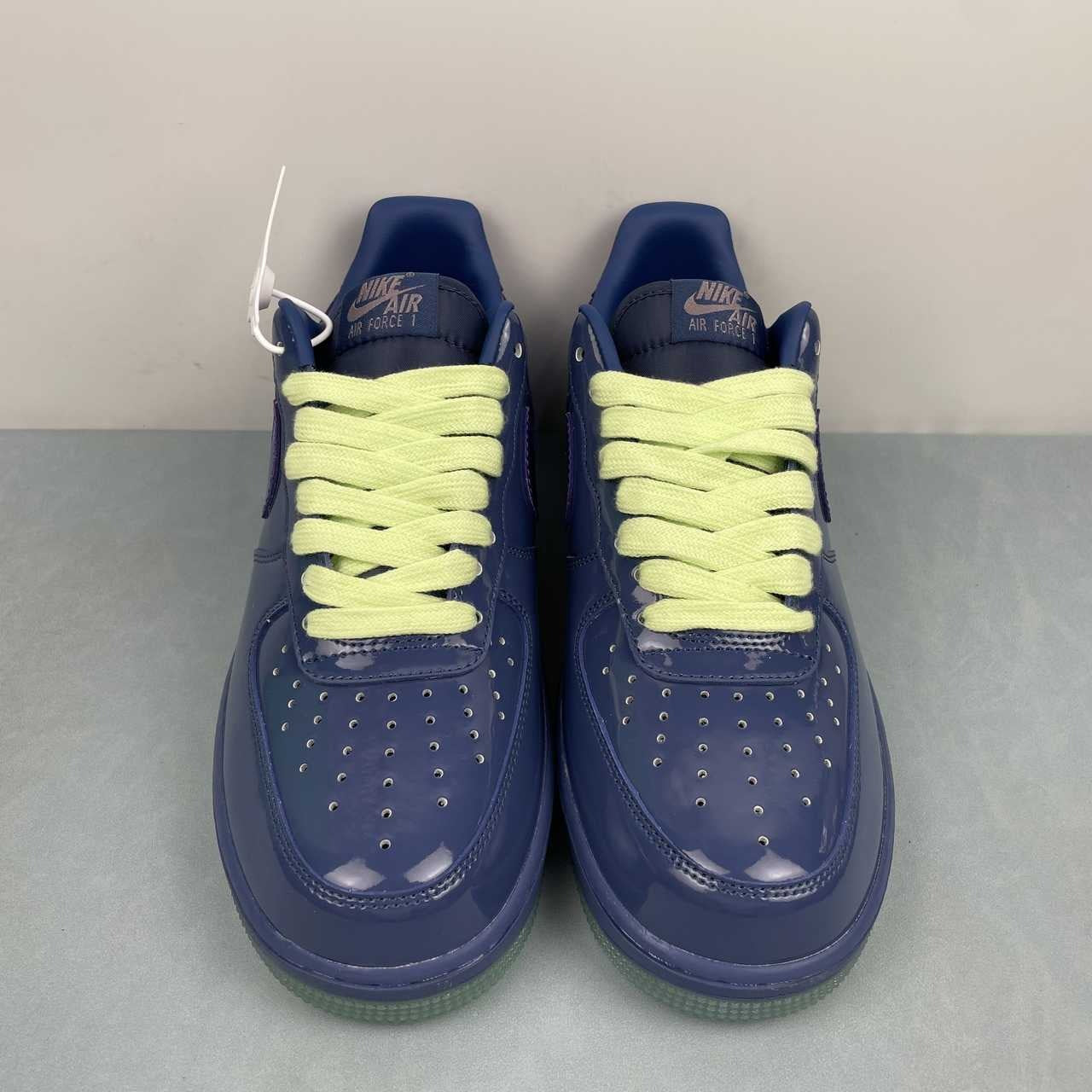 AF1-036 Tonal Navy Patent – pair on surface, three-quarter front view showing lime laces and hang tag