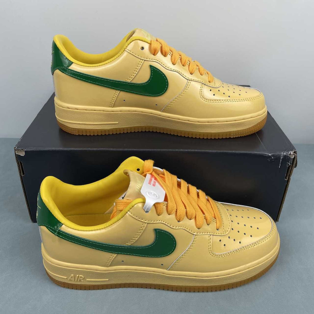 AF1-038 Vanilla Forest Patent – front toe box view showing cream patent upper, yellow laces, and green swoosh tips